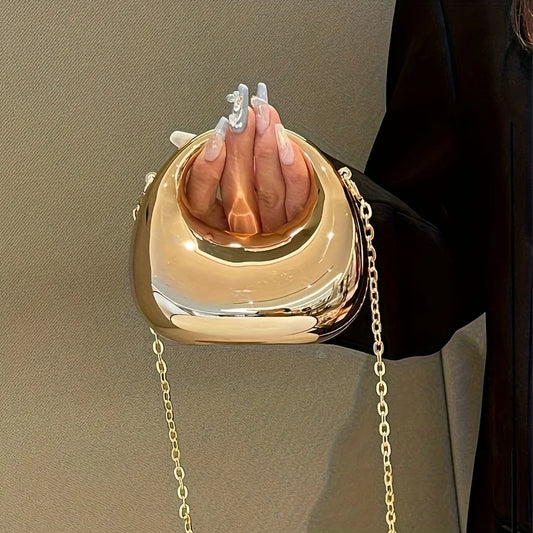 Le trompettiste porte un sac, un sac bandoulière en forme de croissant - un sac de soirée brillant, idéal pour les bals et les tenues à paillettes.