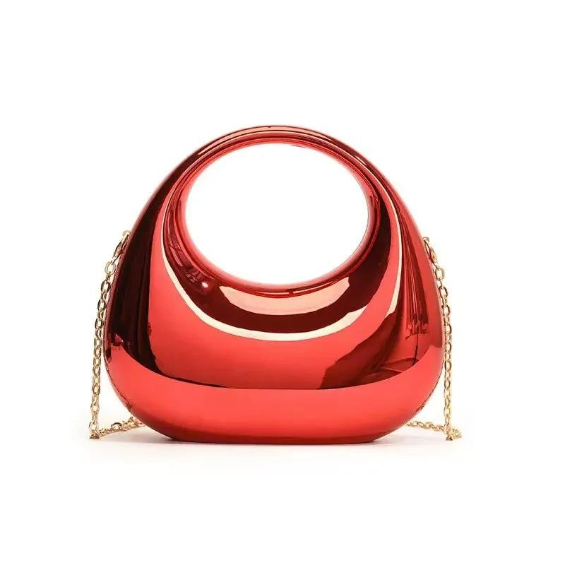 Le trompettiste porte un sac, un sac bandoulière en forme de croissant - un sac de soirée brillant, idéal pour les bals et les tenues à paillettes.