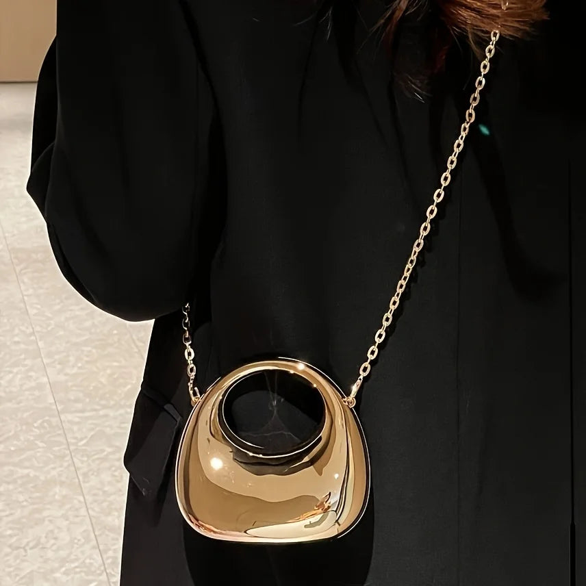 Le trompettiste porte un sac, un sac bandoulière en forme de croissant - un sac de soirée brillant, idéal pour les bals et les tenues à paillettes.
