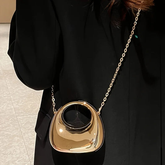 Le trompettiste porte un sac, un sac bandoulière en forme de croissant - un sac de soirée brillant, idéal pour les bals et les tenues à paillettes.